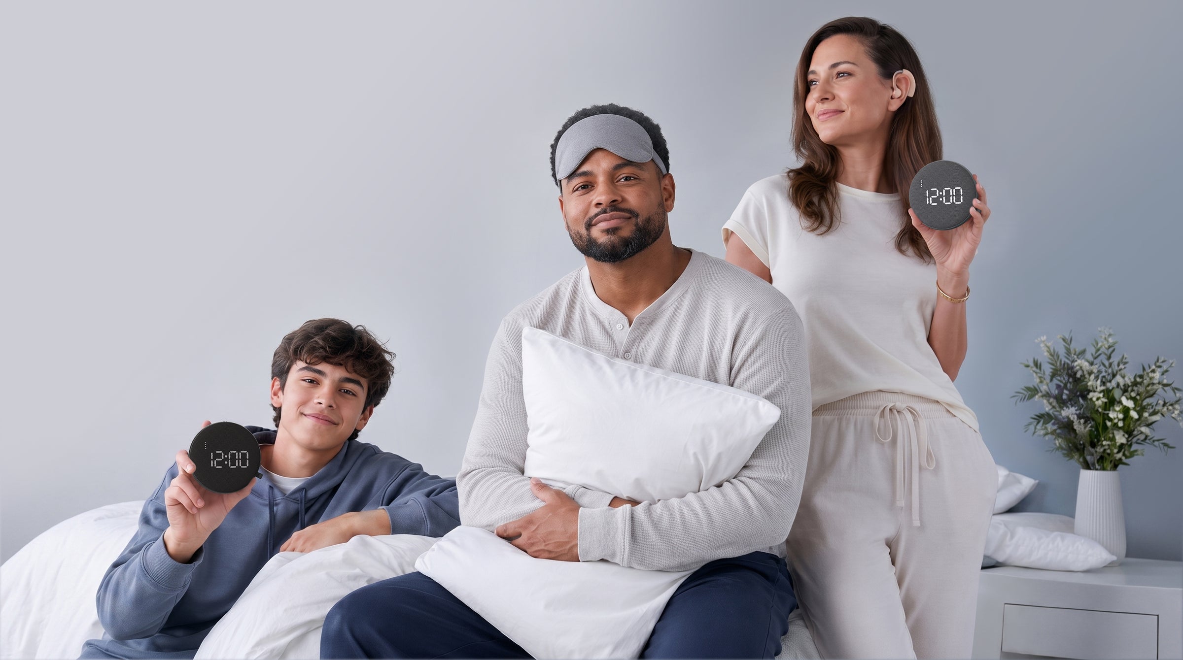 A teen, a heavy sleeper, and a woman holding REACHER GX alarm clocks